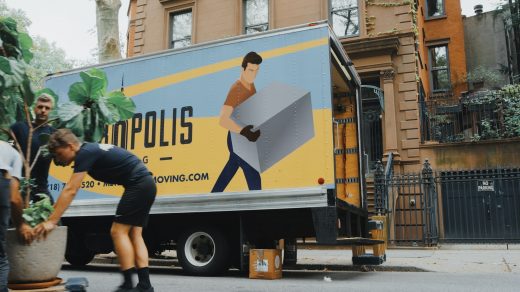 moving a house woman in blue shorts and black boots standing beside yellow and white truck during daytime
