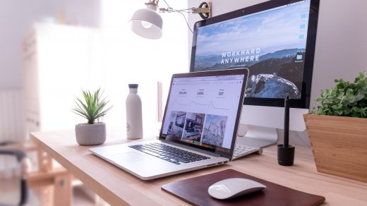 digital marketing MacBook Pro on table beside white iMac and Magic Mouse