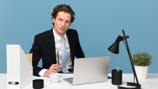 business success man sitting on chair beside laptop computer and teacup