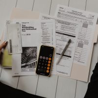 Tax-free wrapper investments person holding paper near pen and calculator