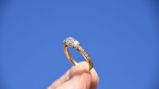 engagement ring person holding gold-colored ring