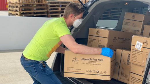 Delivery Management man in green t-shirt and blue denim jeans holding brown cardboard box