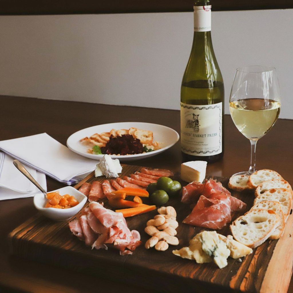 a wooden table topped with a plate of food and a bottle of wine