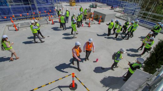 a group of construction workers standing on top of a building