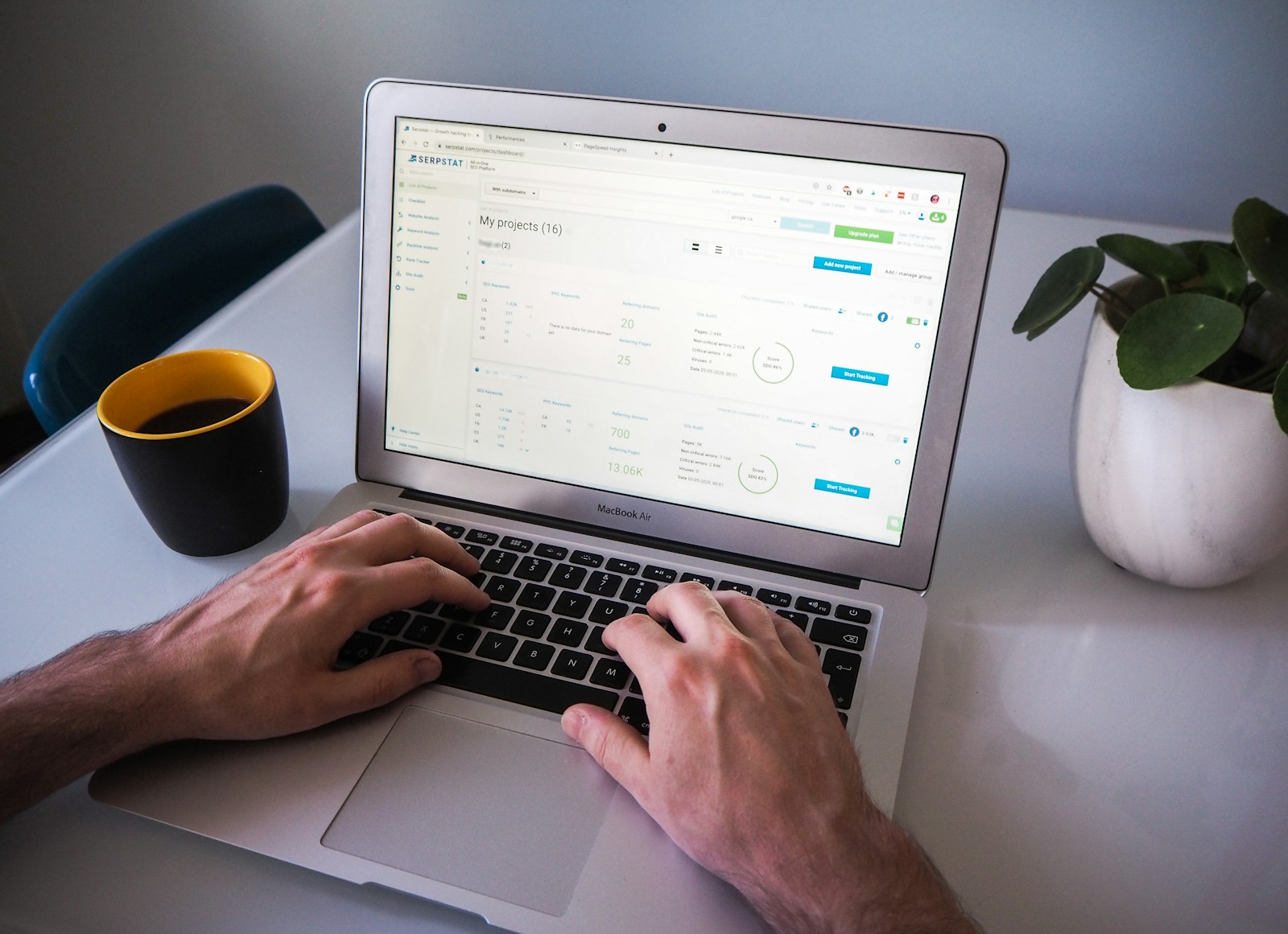 person using macbook air on white table