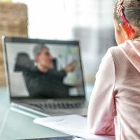 woman in pink long sleeve shirt sitting in front of macbook pro