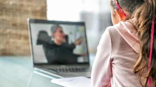 woman in pink long sleeve shirt sitting in front of macbook pro