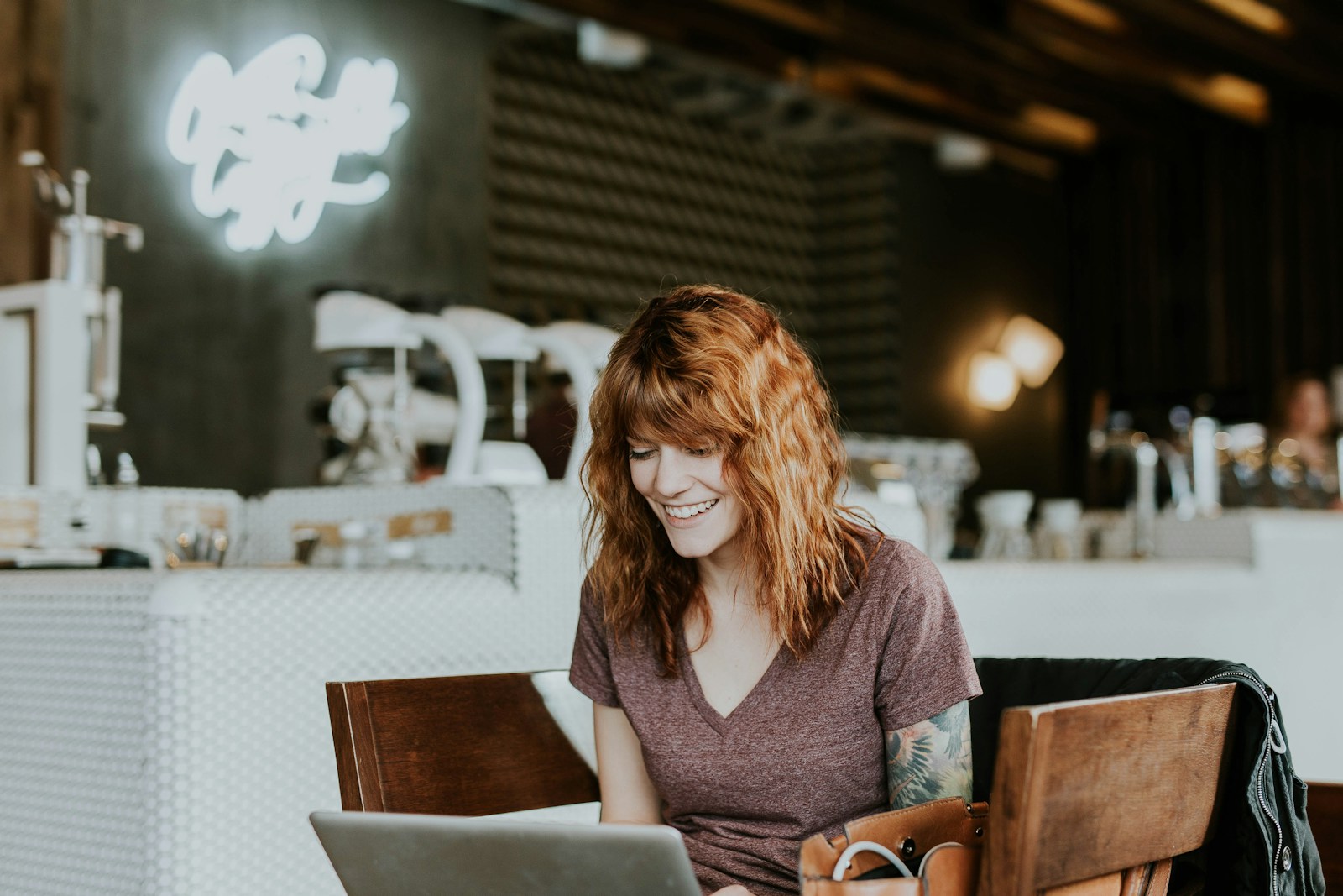 Virtual Vs Hybrid Events- woman sitting on brown wooden chair while using silver laptop computer in room